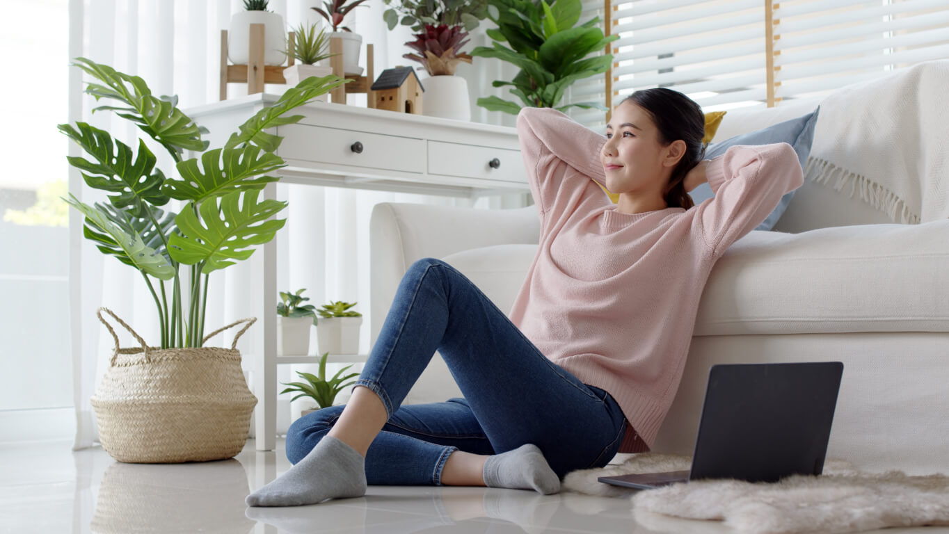 women sits by couch with computer